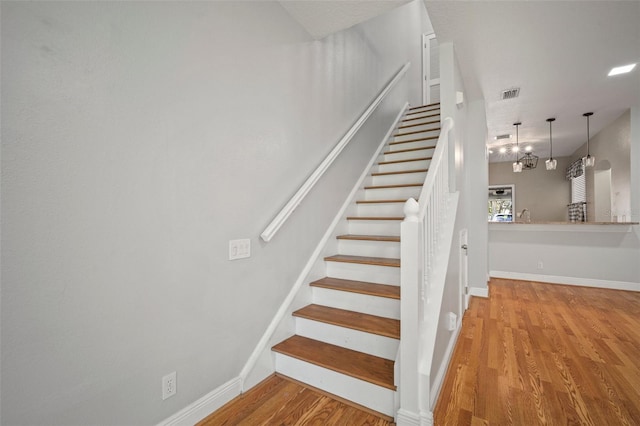 stairs featuring hardwood / wood-style floors