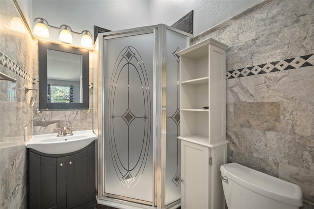 bathroom with toilet, vanity, and tile walls