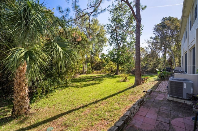 view of yard featuring central air condition unit and a patio