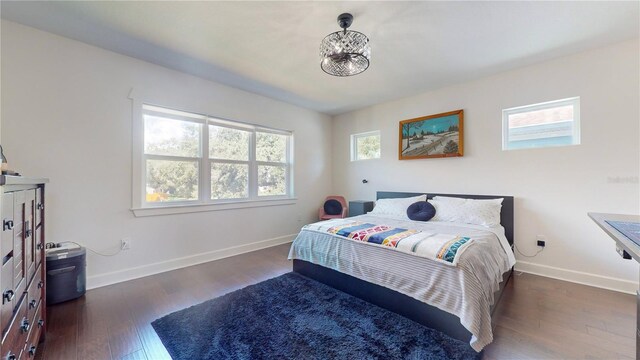 bedroom featuring multiple windows and dark wood-type flooring