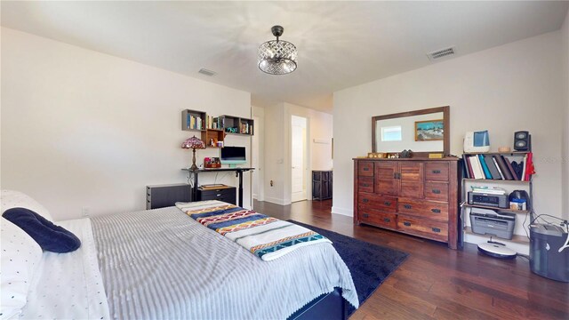 bedroom featuring dark wood-type flooring and a notable chandelier