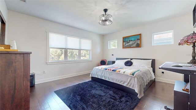 bedroom with multiple windows and dark hardwood / wood-style floors