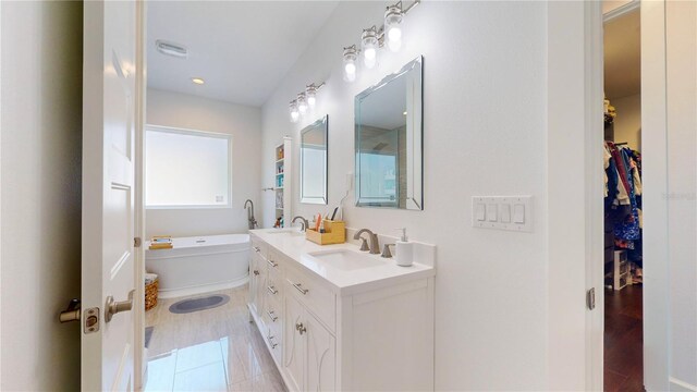 bathroom featuring vanity, hardwood / wood-style flooring, and a bathing tub