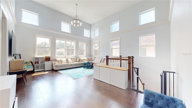 living room with dark hardwood / wood-style flooring, plenty of natural light, and a high ceiling