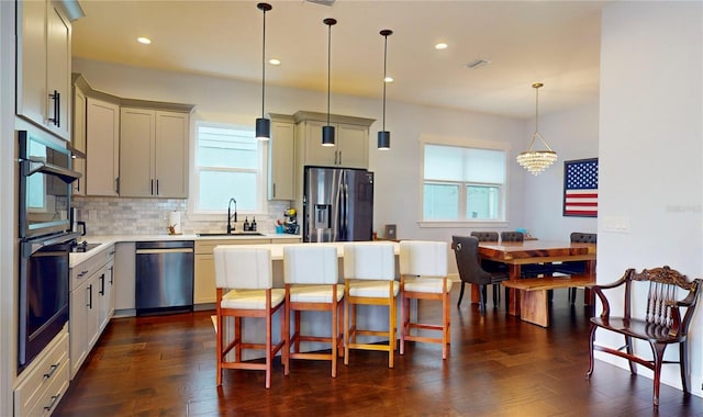 kitchen with appliances with stainless steel finishes, dark hardwood / wood-style flooring, and plenty of natural light