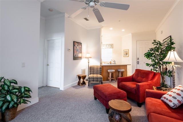 living room with ornamental molding, ceiling fan, sink, and carpet floors