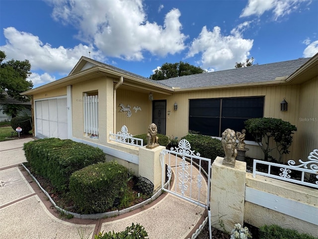 view of front facade with a garage, a gate, and a fenced front yard