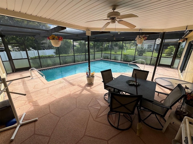 view of pool featuring glass enclosure, ceiling fan, and a patio