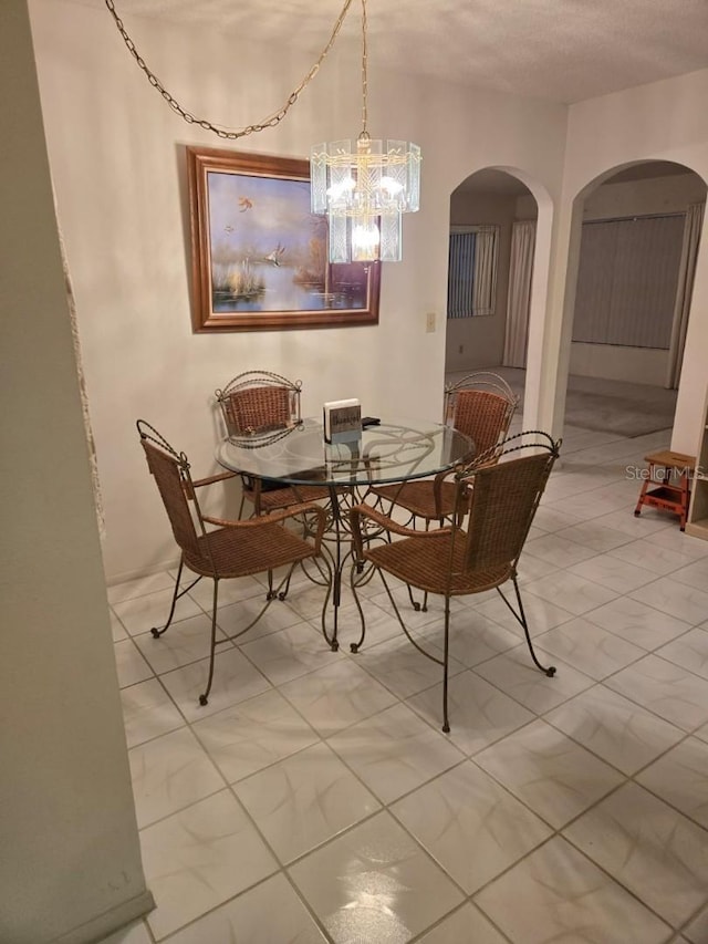 tiled dining area featuring an inviting chandelier