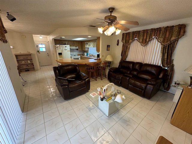 living room with ceiling fan, sink, and a textured ceiling