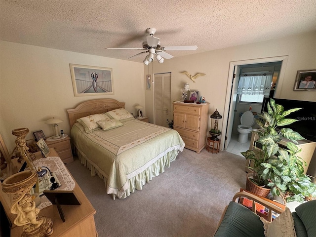 carpeted bedroom featuring a textured ceiling, a closet, ceiling fan, and connected bathroom