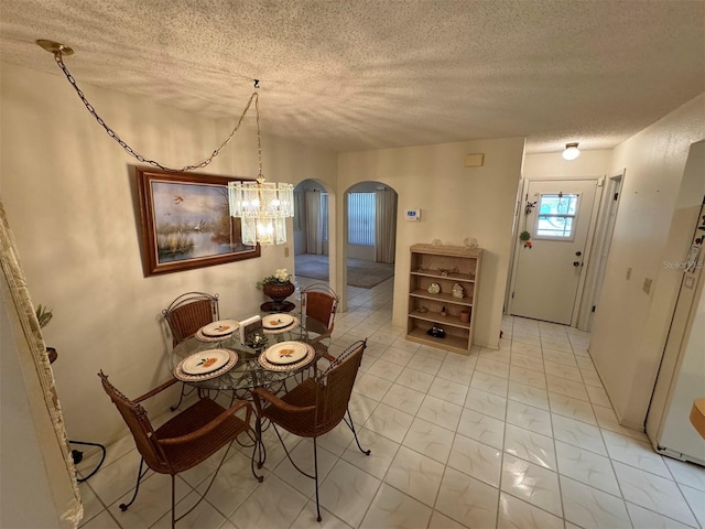 dining area featuring a notable chandelier and a textured ceiling