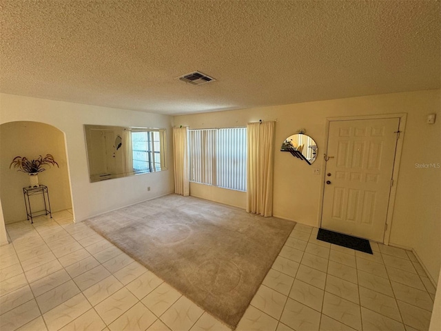 carpeted entrance foyer featuring a textured ceiling