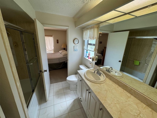 full bathroom featuring vanity, tile patterned floors, combined bath / shower with glass door, toilet, and a textured ceiling