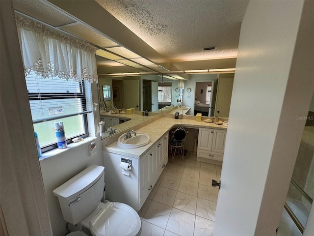 bathroom with a textured ceiling, vanity, and toilet