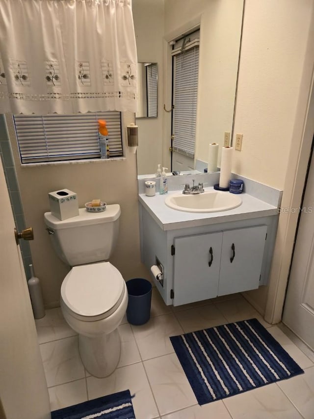 bathroom featuring tile patterned flooring, vanity, and toilet