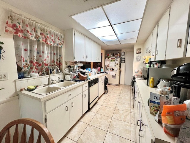 kitchen with white appliances, sink, light tile patterned floors, and white cabinets