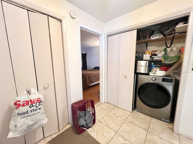 washroom with washer / clothes dryer and light tile patterned floors