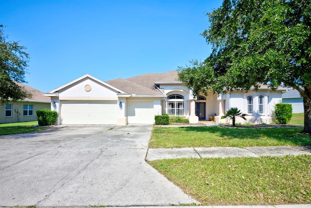 view of front of property featuring a front yard and a garage