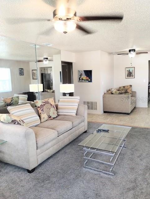 carpeted living room featuring a textured ceiling