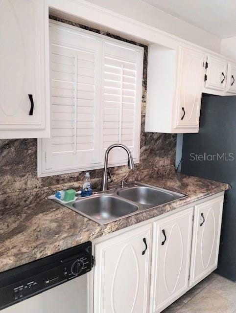 kitchen with stainless steel dishwasher, sink, white cabinets, and decorative backsplash