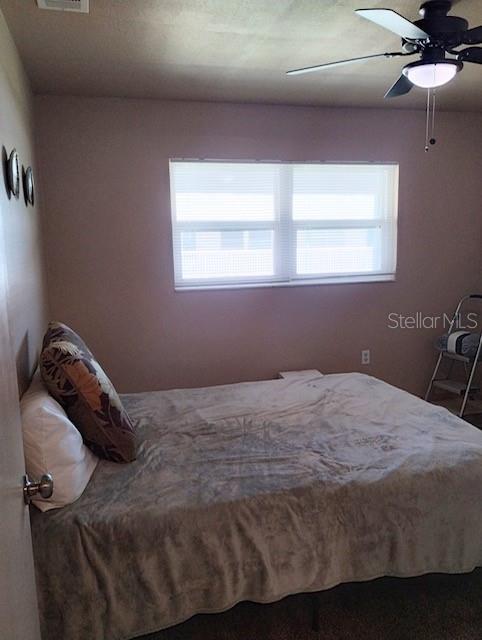 bedroom with ceiling fan and multiple windows