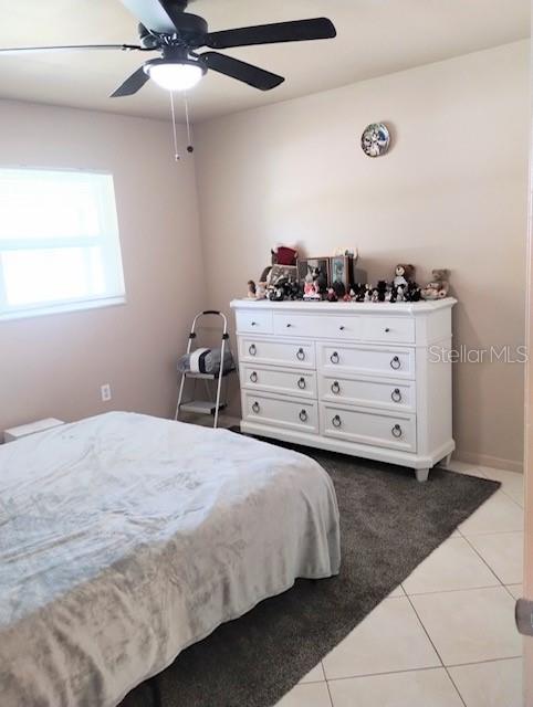 tiled bedroom featuring ceiling fan