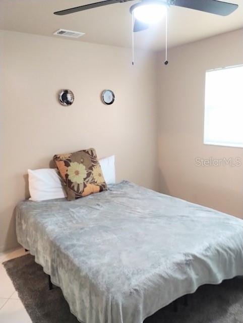 bedroom with light tile patterned floors and ceiling fan