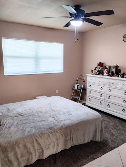 bedroom with light tile patterned flooring and ceiling fan