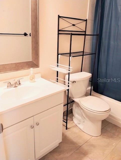 full bathroom featuring vanity, toilet, tile patterned floors, and shower / tub combo with curtain