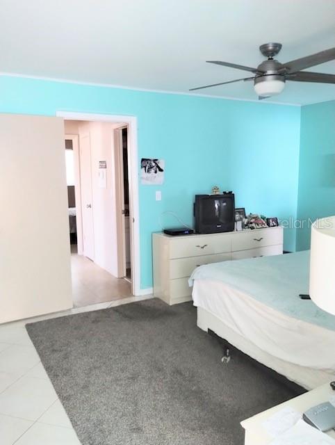 bedroom with ceiling fan and tile patterned floors