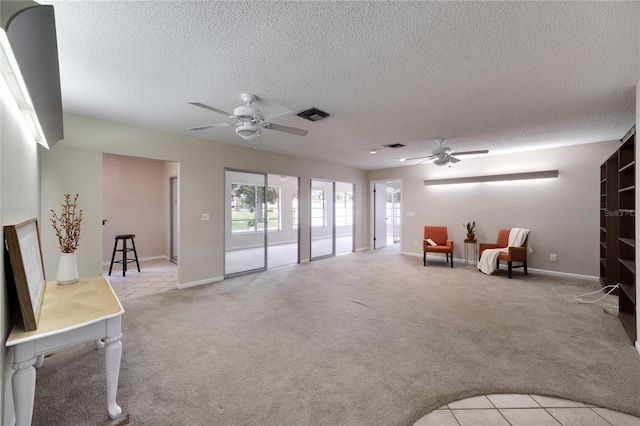 sitting room featuring light carpet, a textured ceiling, and ceiling fan