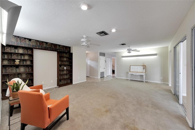 interior space with light carpet, ceiling fan, and a textured ceiling