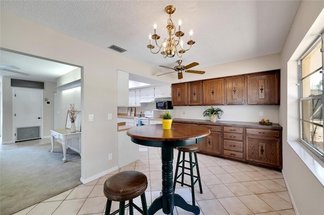 kitchen featuring a breakfast bar, electric stove, a textured ceiling, and light tile patterned floors