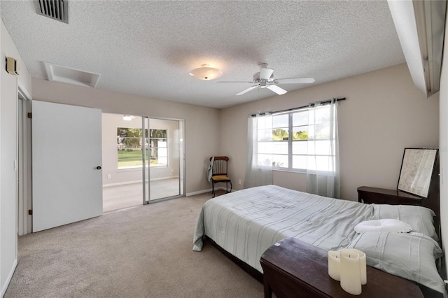 carpeted bedroom featuring ceiling fan, a textured ceiling, and multiple windows