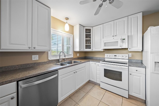 kitchen with light tile patterned flooring, sink, white cabinets, and white appliances