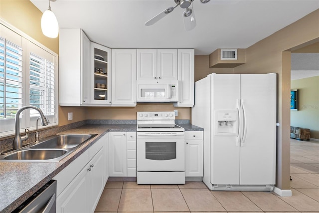 kitchen featuring light tile patterned flooring, decorative light fixtures, sink, white cabinets, and white appliances