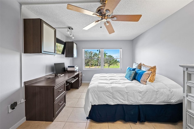 tiled bedroom featuring track lighting, a textured ceiling, and ceiling fan