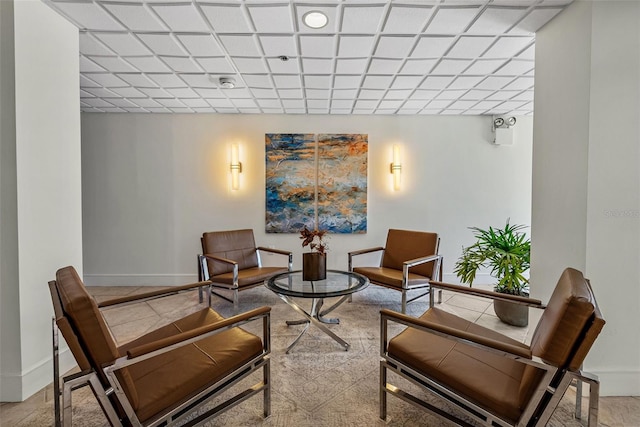 living area with a paneled ceiling