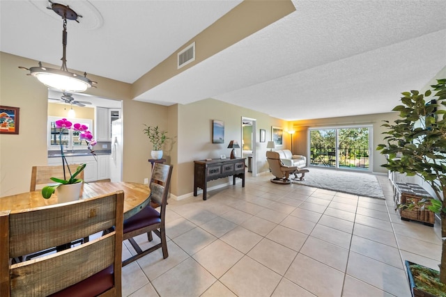 dining area with a textured ceiling and light tile patterned flooring