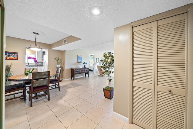 tiled dining space featuring a textured ceiling