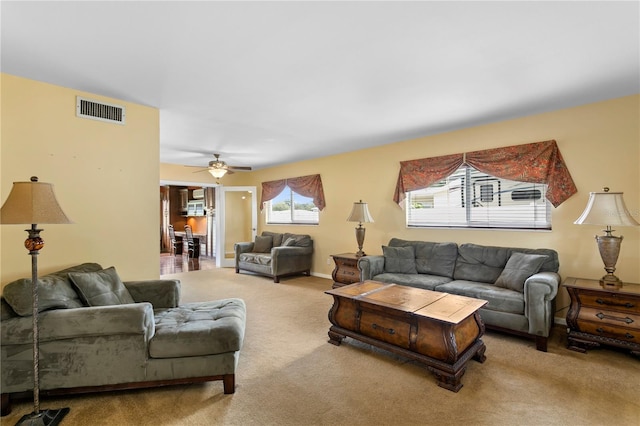 carpeted living room with ceiling fan