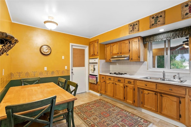 kitchen with sink, decorative backsplash, white gas cooktop, and light tile patterned floors