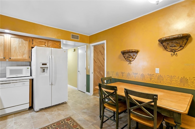 kitchen featuring white appliances and backsplash