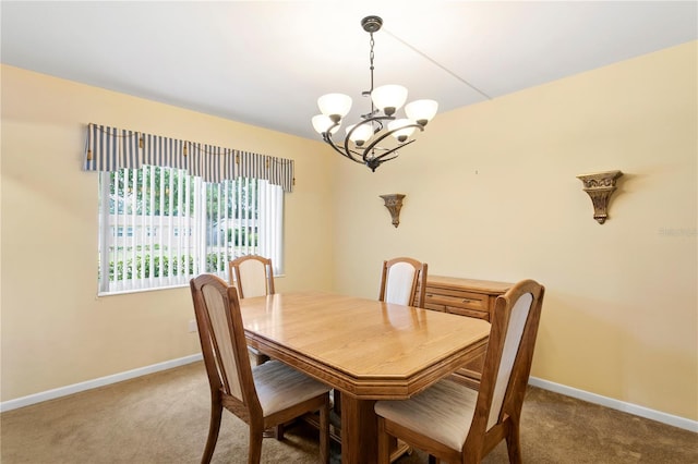 carpeted dining room featuring a notable chandelier