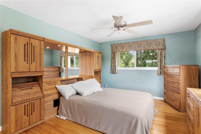 bedroom featuring ceiling fan, multiple windows, and light hardwood / wood-style flooring