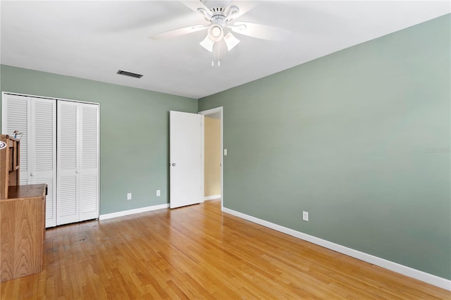 unfurnished bedroom with a closet, hardwood / wood-style flooring, and ceiling fan