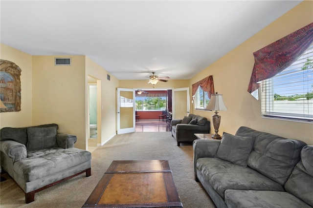 carpeted living room with ceiling fan and a wealth of natural light