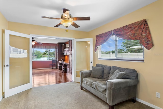 carpeted living room featuring french doors, ceiling fan, and a wealth of natural light