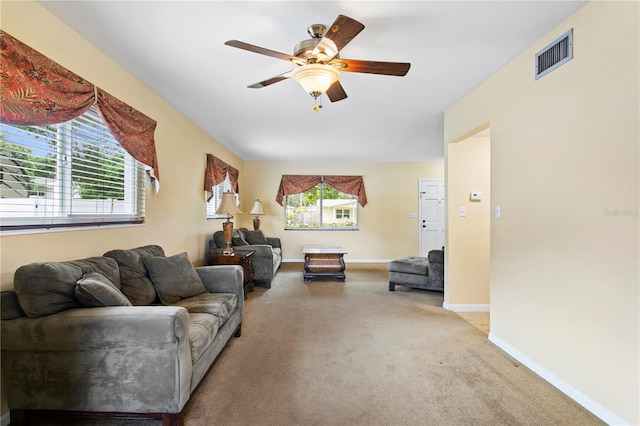 carpeted living room with ceiling fan